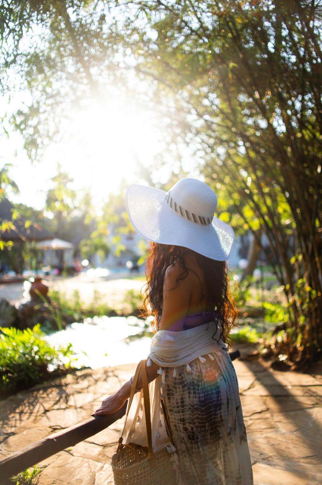 Diamonds Leisure Beach & Golf Resort Diani Beach Esterno foto A woman wearing a sun hat